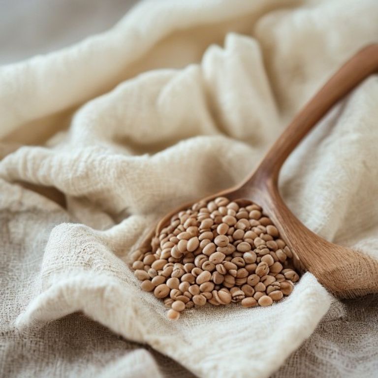 Enkla ingredienser En stilleben med bönor, grönt te och en träsked på ett minimalistiskt bord